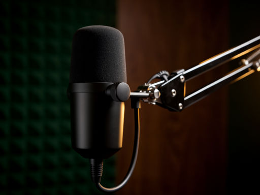 Zwarte podcastmicrofoon op een chroom arm in warm licht met onscherpe groene akoestische panelen en houten accenten op de achtergrond.